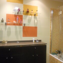 CERÁMICA MULTICOLOR<br>
incrustada en paredes lisas <br>
<br>
SIMIL GRESITE<br>
en zona bañera<br>
<br>
ESTANTERÍA DE CRISTA <br>
ENCIMERA MARMOL COMPAC<br>
sobre mueble funcional de madera